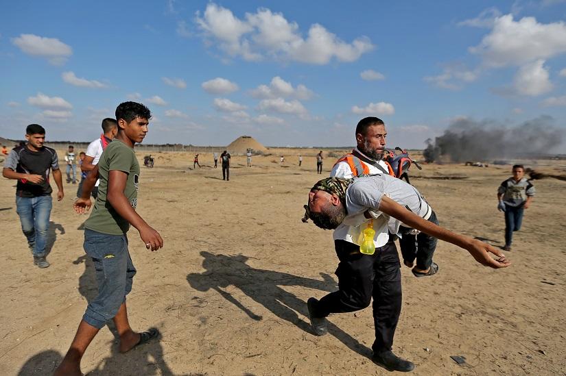 A medic helps a Palestinian demonstrator affected by tear gas during an anti-Israel protest at the Israel-Gaza border fence, in the southern Gaza Strip Nov 1, 2019. REUTERS