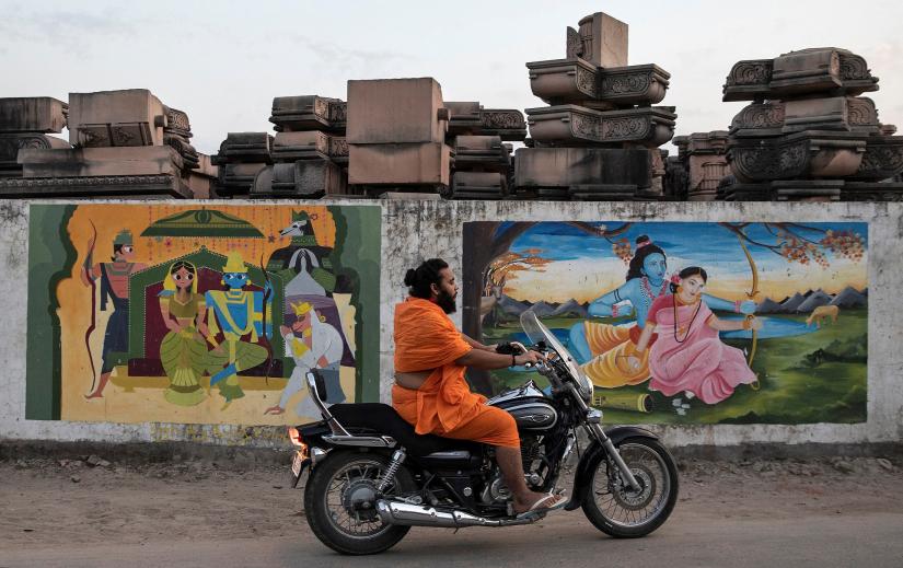 A Hindu priest rides past a workshop where the pillars that Hindu nationalist group Vishva Hindu Parishad (VHP) say will be used to build a Ram temple at the disputed religious site are kept, in Ayodhya, India, October 22, 2019. REUTERS