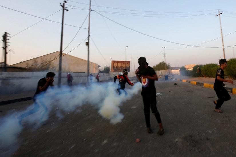Demonstrators run away from tear gas during the ongoing anti-government protests near the Governorate building of Basra, Iraq Nov 8, 2019. REUTERS