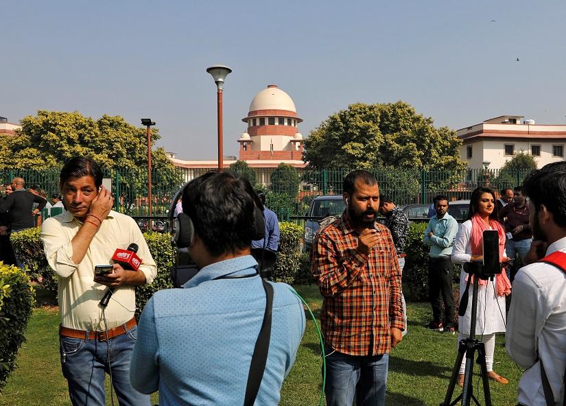 Members of media speak in front of cameras before Supreme Court`s verdict on a disputed religious site, outside the court in New Delhi, India, Nov 9, 2019. REUTERS