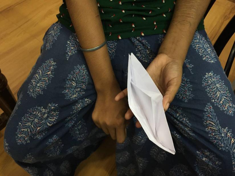 A Bangladeshi trafficking survivor holds a paper boat during an interview at a shelter in West Bengal, India, Sept 9, 2019. Thomson Reuters Foundation