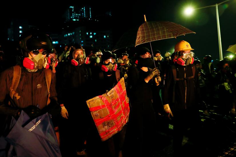 Anti-government protesters take cover during a standoff with riot police at the Chinese University of Hong Kong, Hong Kong, China November 12, 2019. REUTERS