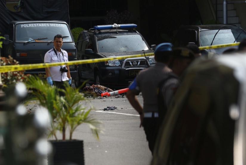 Police keep watch near the blast location after a suspected suicide bombing outside the police headquarters in Medan, Indonesia November 13, 2019. Antara Foto