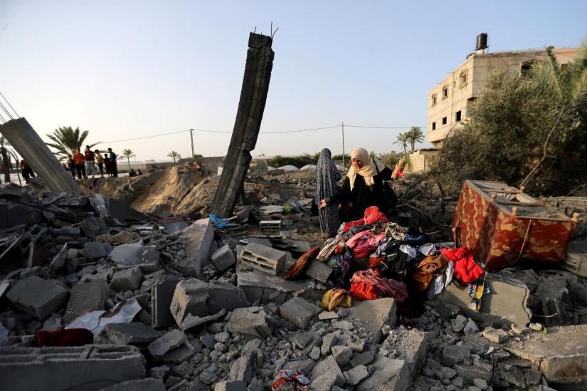 A Palestinian woman inspects a house destroyed in an Israeli air strike in the southern Gaza Strip Nov 13, 2019. REUTERS