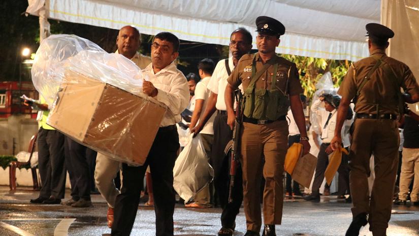 Election officials, assisted by Sri Lankan police officer, arrive with a ballot box to a counting center, after the voting ended during the presidential election day, in Colombo in Colombo, Sri Lanka November 16, 2019. REUTERS