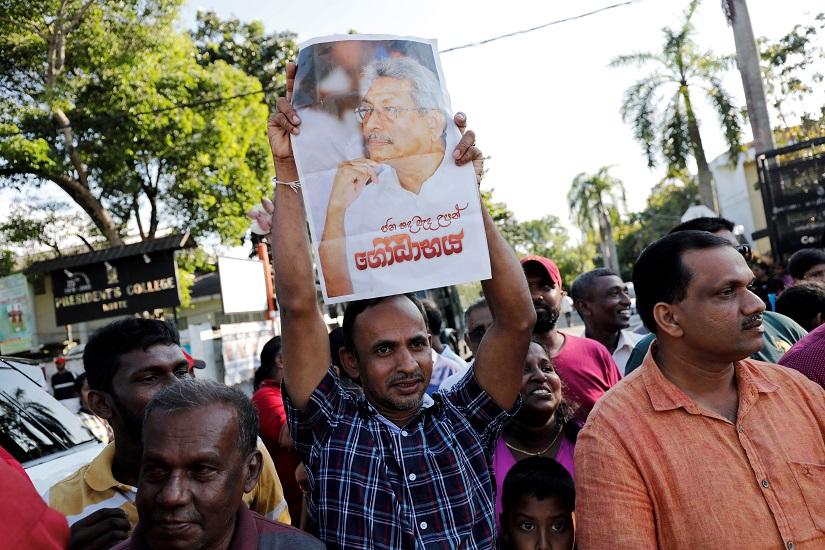 A supporter of Sri Lanka President-elect Gotabaya Rajapaksa holds a picture of him in Colombo, Sri Lanka Nov 17, 2019. REUTERS