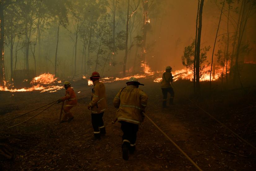 RFS volunteers and NSW Fire and Rescue officers protect a home on Wheelbarrow Ridge Road being impacted by the Gospers Mountain fire near Colo Heights south west of Sydney, Australia, November 19, 2019. AAP Image/Dean Lewins/via REUTERS