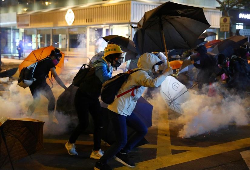 Anti-government protesters run from tear gas during clashes with riot police at Tsim Sha Tsui, in Hong Kong, China, Nov 18, 2019. REUTERS