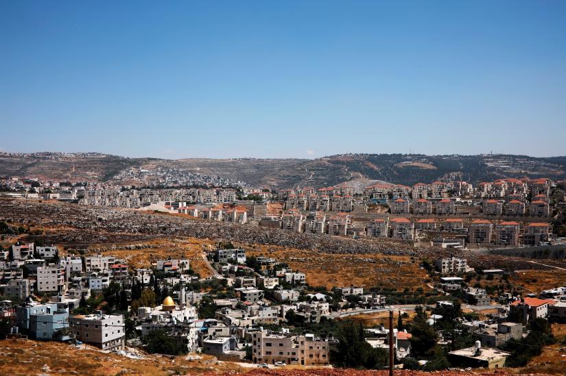 FILE PHOTO: A general view shows Palestinian houses in the village of Wadi Fukin as the Israeli settlement of Beitar Illit is seen in the background, in the occupied West Bank, June, 19, 2019. Beitar Illit was built in the 1990s for Israel`s Ultra-Orthodox Jewish community and is one of the largest and fastest growing settlements in the West Bank. REUTERS