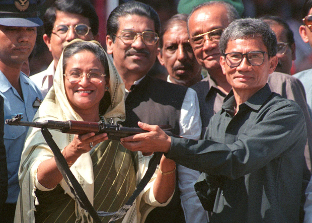 Jyotirindra Bodhipriya Larma (right), hands over a rifle to Prime Minister Sheikh Hasina during a weapon-surrendering ceremony following the signing of a peace pact for the Chittagong Hill Tracts two months earlier, Feb. 11, 1998.