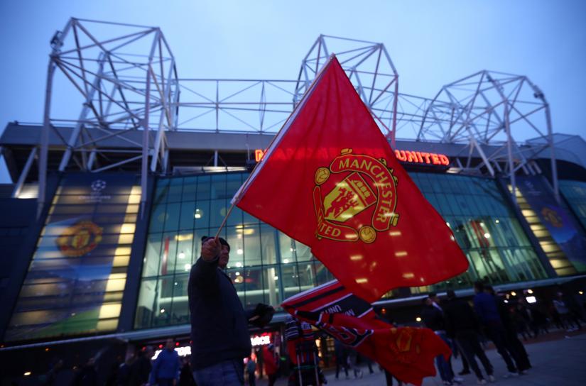 A MANU fan waving club flag in front of the stadium at Old Trafford ahead of a champions league clash against Juventus. Oct 23. 2018. REUTERS