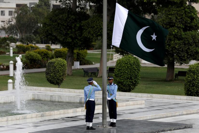 FILE PHOTO: A member of the Pakistan air force salutes as the national flag is raised at the mausoleum of Muhammad Ali Jinnah during Defence Day ceremonies, or Pakistan`s Memorial Day, in Karachi, Pakistan Sept 6, 2018. REUTERS