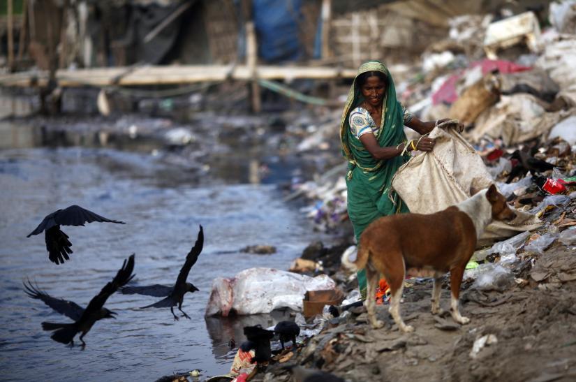 A woman collects garbage from a dump along the polluted Buriganga river in Dhaka, Bangladesh, June 5, 2014. REUTERS/File Photo