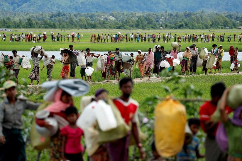 FILE PHOTO: Rohingya refugees, who crossed the border from Myanmar two days before, walk after they received permission from the Bangladeshi army to continue on to the refugee camps, in Palang Khali, near Cox`s Bazar, Bangladesh Oct 19, 2017. REUTERS