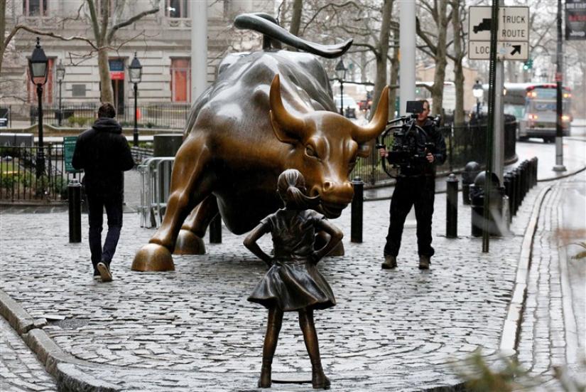 A camera man films a statue of a girl facing the Wall St. Bull, as part of a campaign by U.S. fund manager State Street to push companies to put women on their boards, in the financial district in New York, on March 7. Reuters