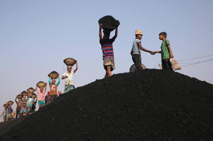 Coal workers are seen at a market as they unload a ferry in Dhaka, Bangladesh, January 13, 2019. Reuters/File Photo
