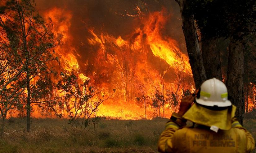 FILE PHOTO: A firefighter on property protection watches the progress of bushfires in Old Bar, New South Wales, Australia Nov 9, 2019. AAP Image/via REUTERS