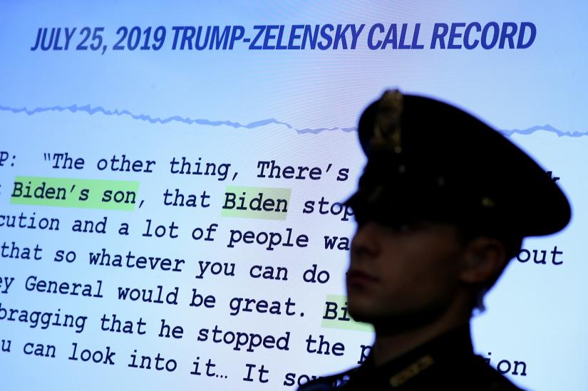 FILE PHOTO: A Capitol Hill Police officer is silhouetted before a Trump-Zelensky call record on a screen, as Fiona Hill, former senior director for Europe and Russia on the National Security Council, and David Holmes, political counselor at the U.S Embassy in Kiev, testify before a House Intelligence Committee hearing as part of the impeachment inquiry into U.S. President Donald Trump on Capitol Hill in Washington, U.S., November 21, 2019. REUTERS