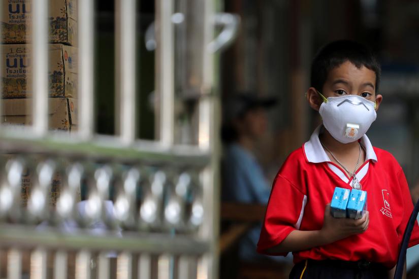A student wears a mask as he waits to be picked up, as classes in over 400 Bangkok schools have been cancelled due to worsening air pollution, at a public school in Bangkok, Thailand, January 30, 2019. REUTERS