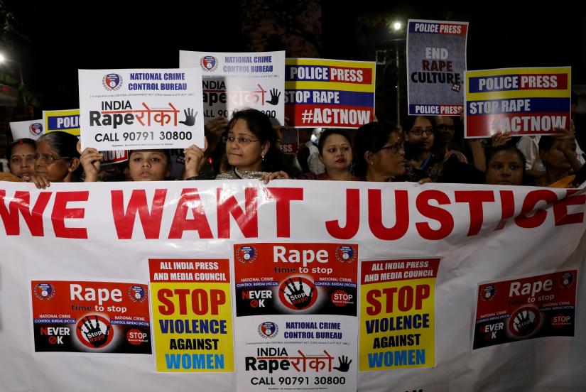 Women display a banner and placards as they attend a protest march against the alleged rape and murder of a 27-year-old woman, in Kolkata, India, December 4, 2019. REUTERS