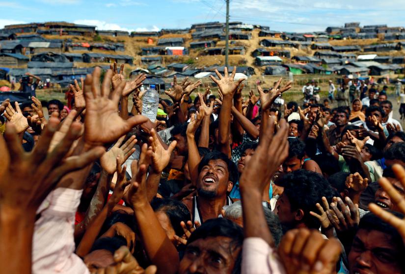 FILE PHOTO: Rohingya refugees stretch their hands to receive aid distributed by local organisations at Balukhali makeshift refugee camp in Cox`s Bazar, Bangladesh, September 14, 2017. REUTERS