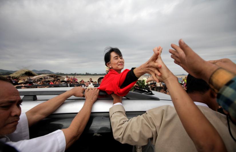 FILE PHOTO: Myanmar pro-democracy leader Aung San Suu Kyi shakes hands with supporters after giving a speech in Monywa, Myanmar November 30, 2012. REUTERS