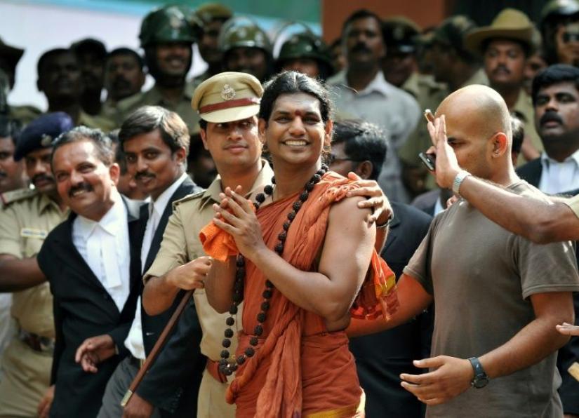 Police escort controversial Hindu Godman Swami Nityananda (center) in 2012 after he appeared at a bail hearing in Ramanagar District, some 50 kilometres from Bangalore, India. Photo: Yahoo
