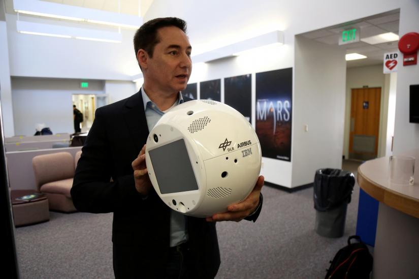 FILE PHOTO: Bret Greenstein, IBM Global Vice President of Watson Internet of Things Offerings, holds a clone of an artificial intelligence bot named CIMON, at the Kennedy Space Center in Florida, U.S., June 28, 2018.