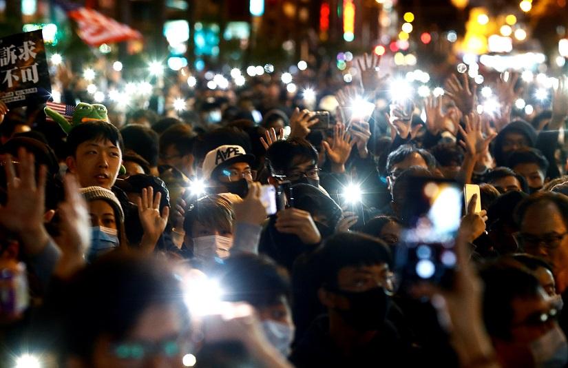 Protesters raise their hands and mobile phones with lights on during a Human Rights Day march, organised by the Civil Human Right Front, in Hong Kong, China Dec 8, 2019. REUTERS