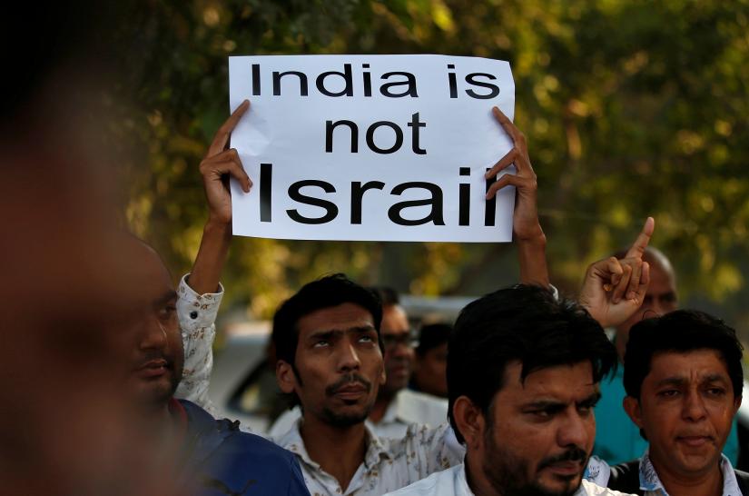 A demonstrator displays a placard during a protest against the Citizenship Amendment Bill, a bill that seeks to give citizenship to religious minorities persecuted in neighbouring Muslim countries, in Ahmedabad, India, December 9, 2019. REUTERS