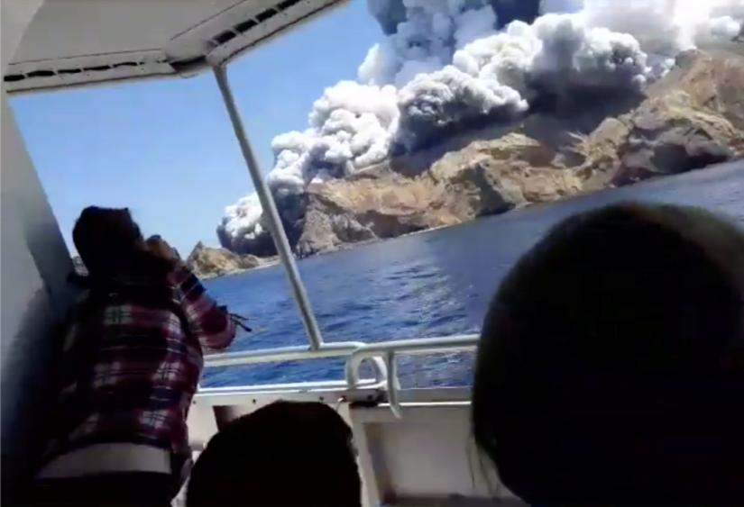 People on a boat react as smoke billows from the volcanic eruption of Whakaari, also known as White Island, New Zealand Dec 9, 2019 in this picture grab obtained from a social media video. INSTAGRAM @ALLESSANDROKAUFFMANN/via REUTERS