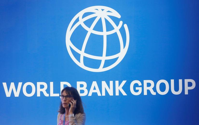 A participant stands near a logo of World Bank at the International Monetary Fund - World Bank Annual Meeting 2018 in Nusa Dua, Bali, Indonesia, October 12, 2018. REUTERS