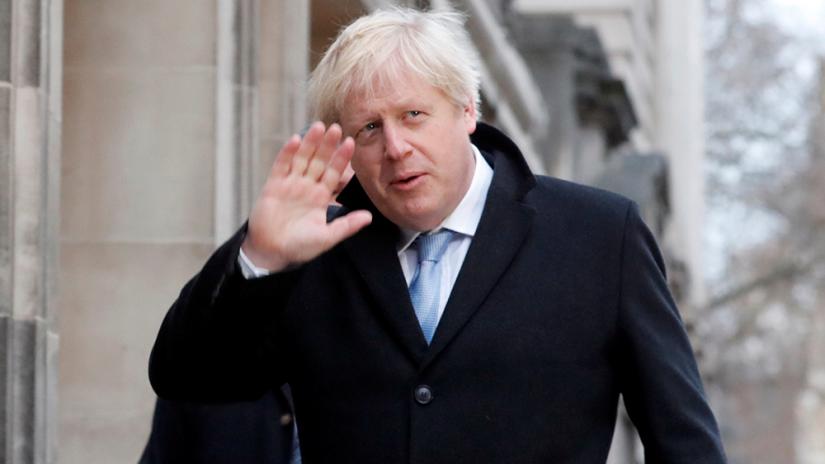 Britain`s Prime Minister Boris Johnson waves as he arrives at a polling station, at the Methodist Central Hall, to vote in the general election in London, Britain, December 12, 2019. REUTERS