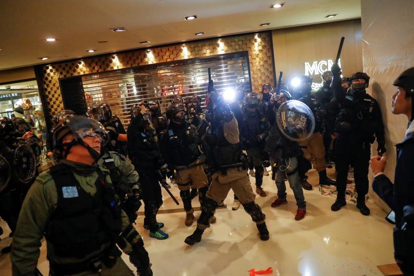 A police officer aims his weapon during an anti-government protest inside a mall, in Hong Kong, China December 15, 2019. REUTERS