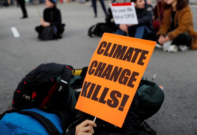 climate activist holds a sign as people take part in a Fridays for Future protest at the U.N. Climate Change Conference (COP25) venue in Madrid, Spain, December 13, 2019. REUTERS