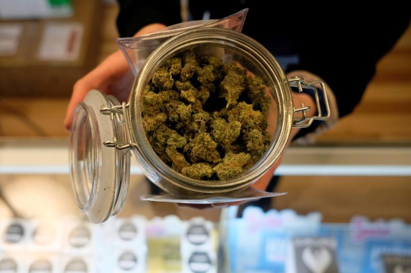 FILE PHOTO: An employee holds a jar of marijuana on sale at the Greenstone Provisions after it became legal in the state to sell recreational marijuana to customers over 21 years old in Ann Arbor, Michigan, US, Dec 3, 2019. REUTERS