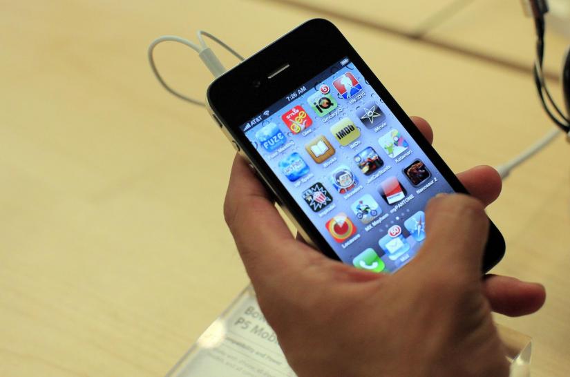 FILE PHOTO: A customer looks at an iPhone 4 at the Apple Store 5th Avenue in New York, in this June 24, 2010. REUTERS