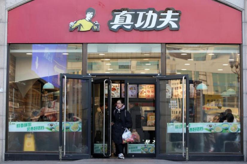 A woman walks out of a restaurant of Chinese fast food chain Real Kungfu at Beijing Railway Station in Beijing, China December 27, 2019. REUTERS