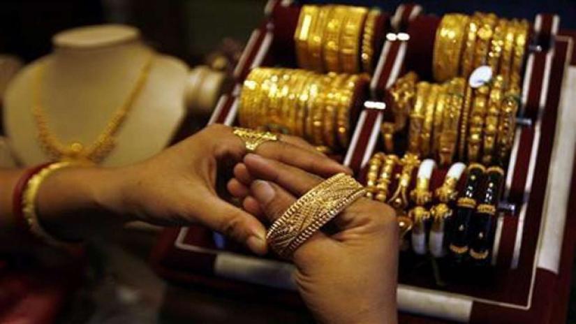 A woman wears a gold bangle at a jewellery shop in Siliguri October 1, 2008. REUTERS/File Photo
