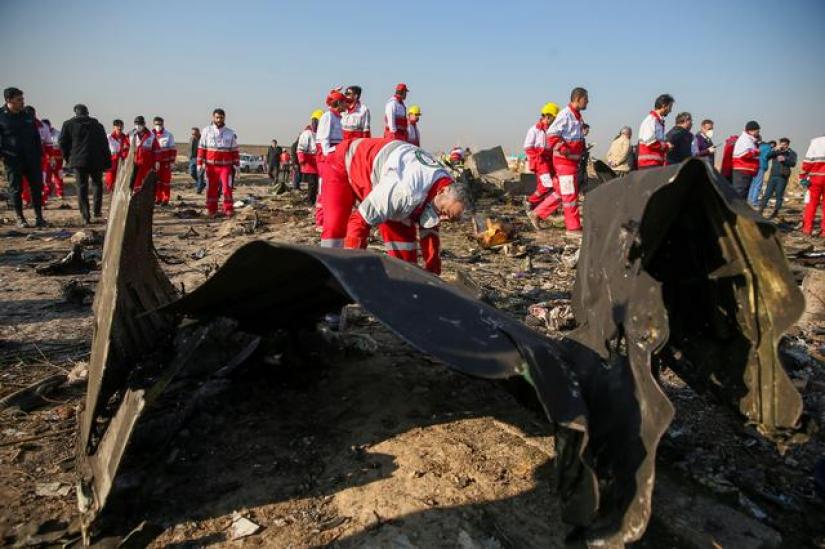 Red Crescent workers check the debris from the Ukraine International Airlines plane, that crashed after take-off from Iran`s Imam Khomeini airport, on the outskirts of Tehran, Iran January 8, 2020. Nazanin Tabatabaee/WANA (West Asia News Agency) via REUTERS