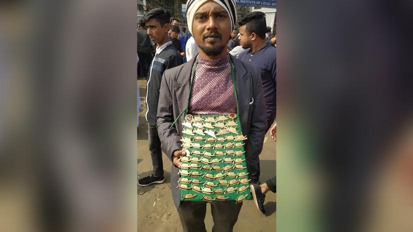 A hawker selling pins with the 'boat,' the electoral symbol of Awami League.