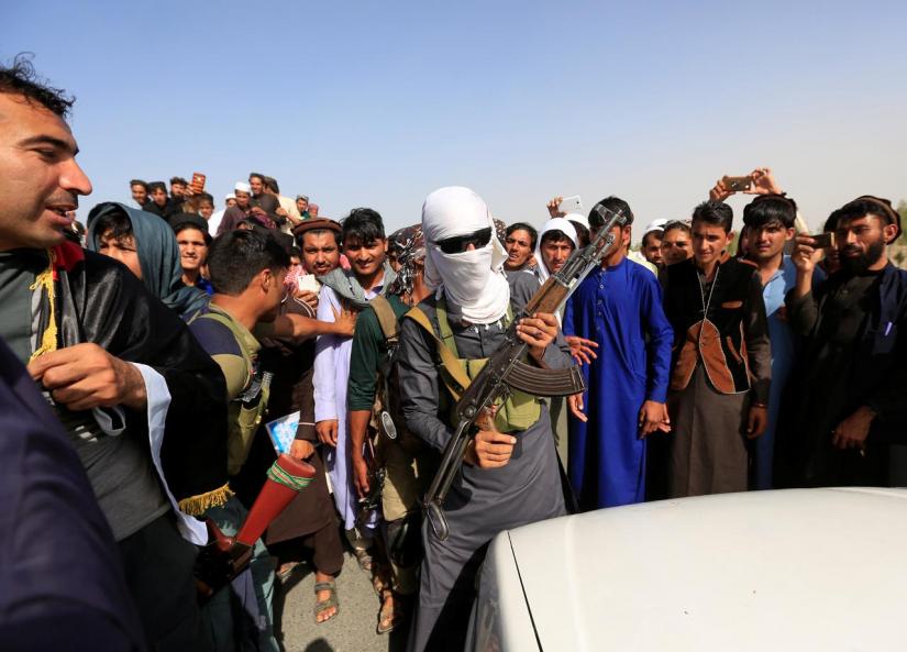 FILE PHOTO: A Taliban (C) stands celebrates ceasefire with people in Rodat district of Nangarhar province, Afghanistan Jun 16, 2018. REUTERS
