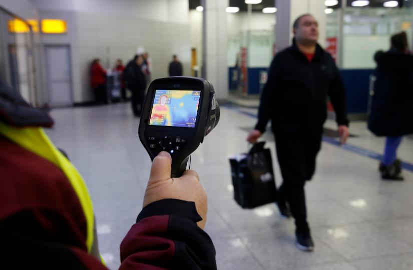 Kazakh sanitary-epidemiological service worker uses a thermal scanner to detect travellers from China who may have symptoms possibly connected with the previously unknown coronavirus, at Almaty International Airport, Kazakhstan January 21, 2020. REUTERS
