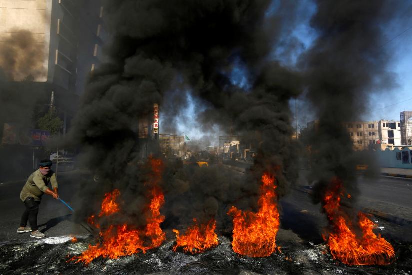 A man burns tires during ongoing anti-government protests in Najaf, Iraq Jan 20, 2020. REUTERS