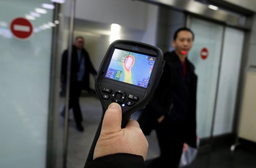 Kazakh sanitary-epidemiological service worker uses a thermal scanner to detect travellers from China who may have symptoms possibly connected with the previously unknown coronavirus, at Almaty International Airport, Kazakhstan January 21, 2020. REUTERS