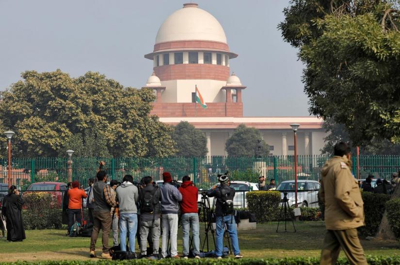 Television journalists are seen outside the premises of the Supreme Court in New Delhi, Jan 22, 2020. REUTERS