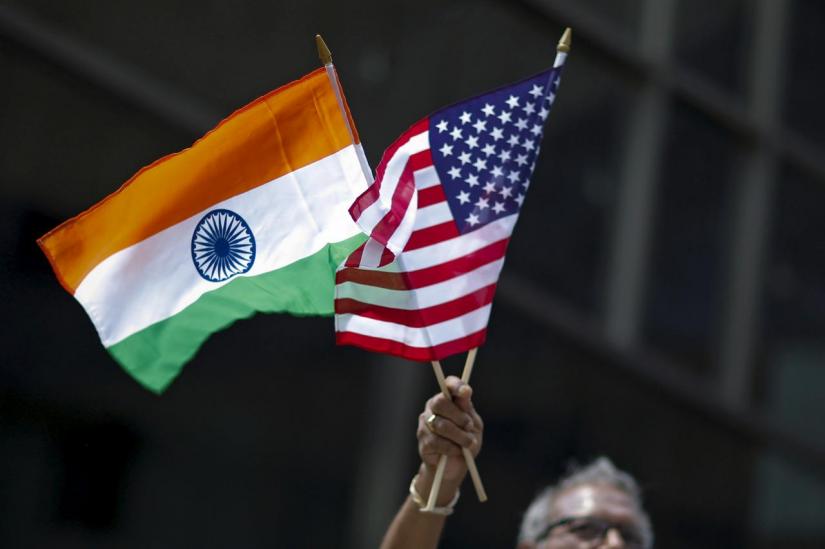 FILE PHOTO: A man holds the flags of India and the U.S. while people take part in the 35th India Day Parade in New York Aug 16, 2015. REUTERS