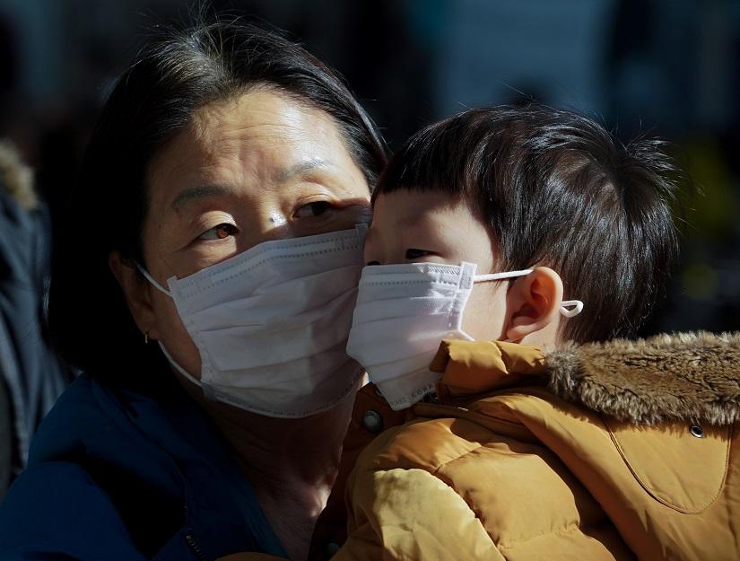 A mother and her child wear a mask to prevent contacting a new coronavirus in Seoul, South Korea, Jan 26, 2020. Yonhap via REUTERS