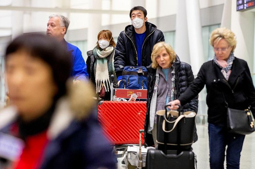 Travellers wear masks at Pearson airport arrivals, shortly after Toronto Public Health received notification of Canada`s first presumptive confirmed case of coronavirus, in Toronto, Ontario, Canada Jan 25, 2020. REUTERS