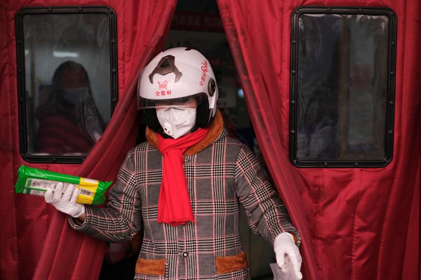 A woman wearing a face mask walks out of a supermarket, as the country is hit by an outbreak of the new coronavirus, in Beijing, China January 26, 2020. REUTERS